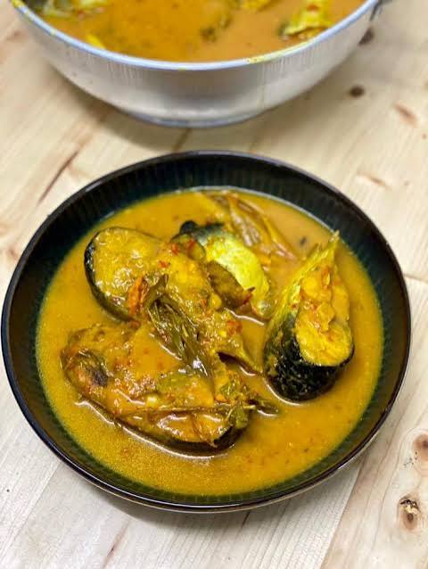 Semangkuk gulai patin tempoyak khas Melayu dengan kuah kuning kental dan potongan ikan patin segar